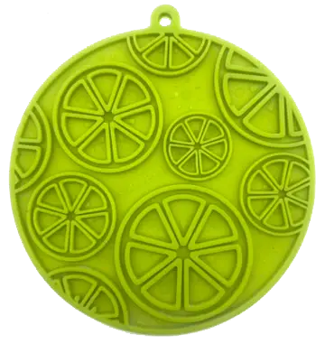 Frilagt billede af grøn citrus-design slikkemåtte fra SodaPup med ophængsøje og sugekopper – perfekt til fodringsaktiviteter.